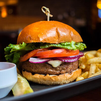 Rich burger with vegetables, sauce and fries
