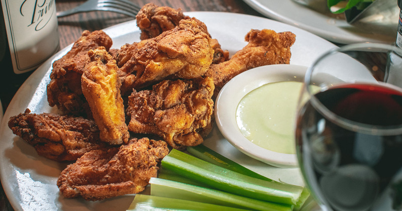Fried chicken and vegetables with dip and a glass of red wine
