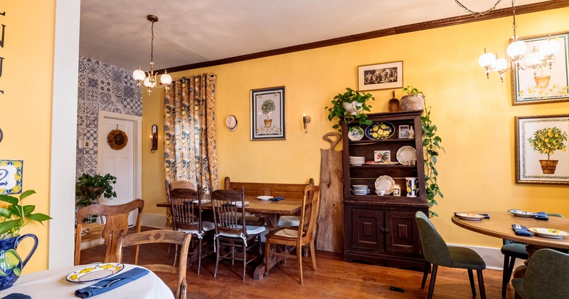 Interior, dining area, tables with chairs, vintage wooden cabinet, paintings as a decoration