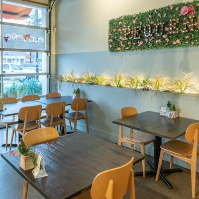 Tables at the seating area, a wall decorated with herbs