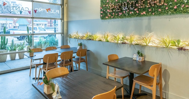 Tables at the seating area, a wall decorated with herbs