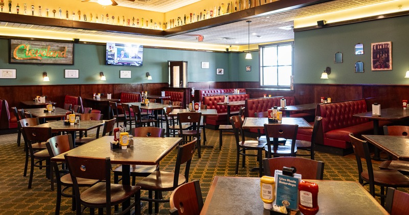 Interior of spacious and cozy dining area with tables and chairs, and upholstered dining booths