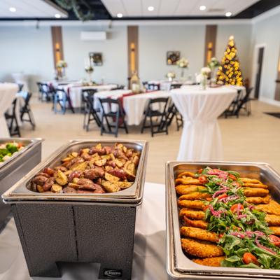 Buffet trays with breaded chicken and roasted vegetables.