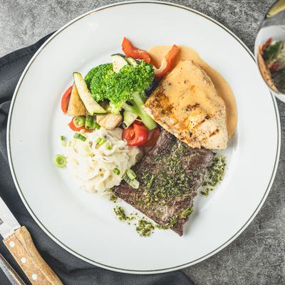 Grilled skirt steak and chicken breast, with chimichurri, mashed potatoes, and veggies.