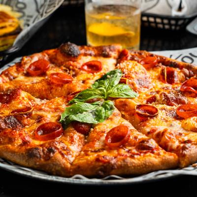 Pepperoni pizza garnished with fresh basil.