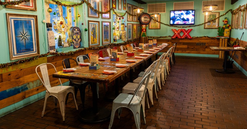 Colorful interior with long table, metal chairs and colorful pictures on the wall