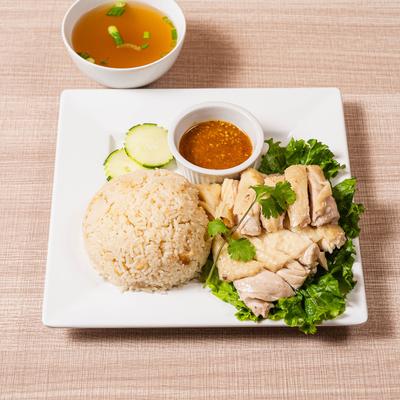 Poached chicken with rice,  chili-ginger sauce, and broth.