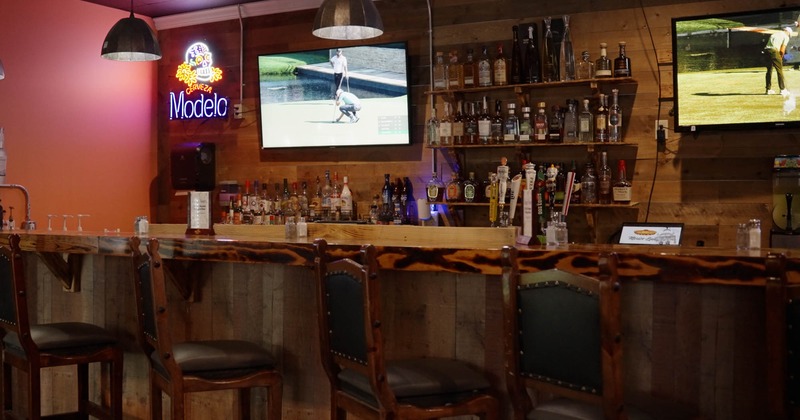 Interior, bar area, bar with wooden front and top, bar stools, drink shelves in the back
