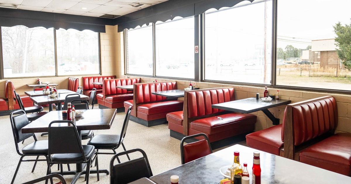 Interior, tables and chairs on the left and booths on the right
