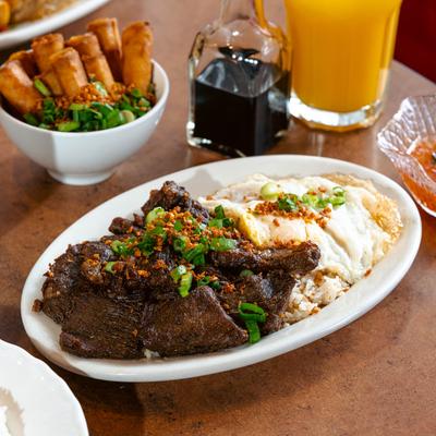 Filipino beef tapa with drinks and sides.