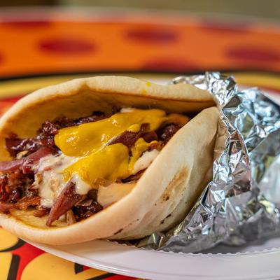Polish Taco, with smoked sausage, bacon, caramelizes onion, sauerkraut, sauce, and mustard.