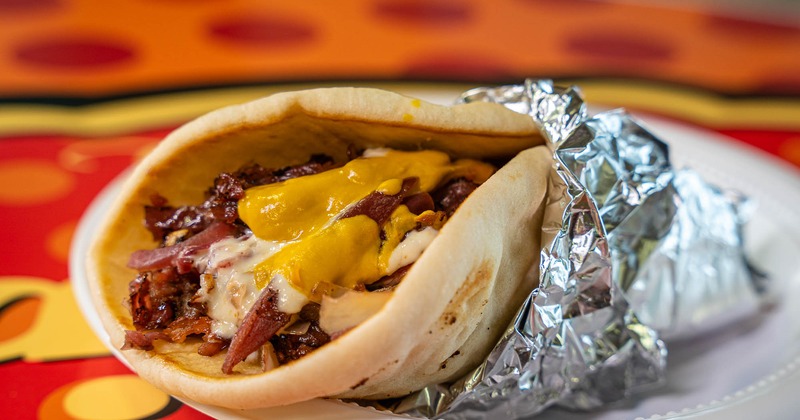 Polish Taco, with smoked sausage, bacon, caramelizes onion, sauerkraut, sauce, and mustard