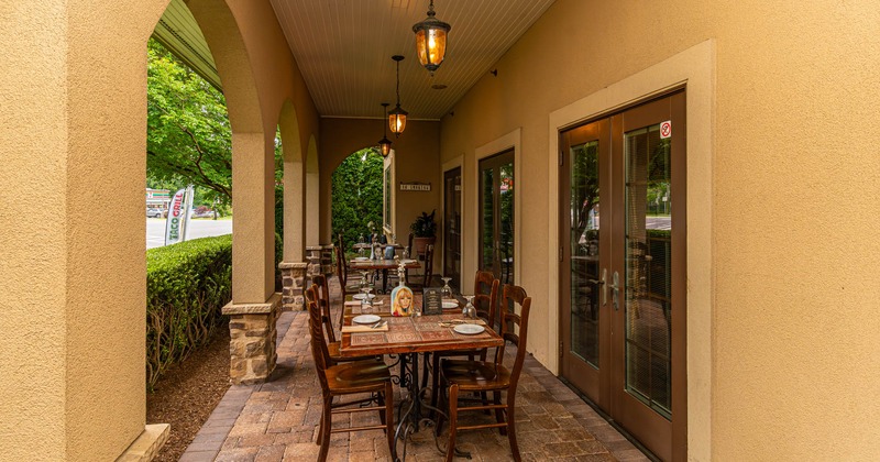 Exterior, patio, covered seating area, wooden top tables for four, stone pavement