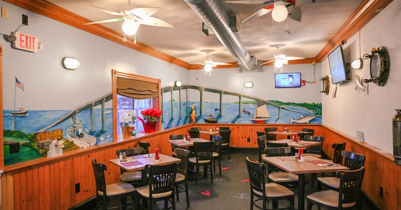 Interior, dining area, tables and chairs, room decorated with mural art, TVs on the walls