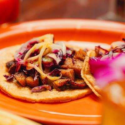 Pork belly tacos topped with shredded cabbage.