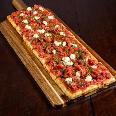 Roman-style pizza topped with roasted tomatoes and mozzarella cheese.