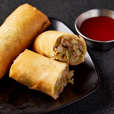 Lumpia with pork and veggies, served with a red sauce.