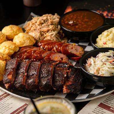 Bubbie's Family Feast platter with meats and sides on it.