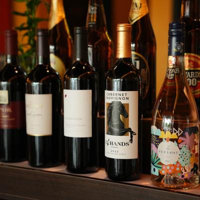Selection of wines in bottles arranged on a shelf.