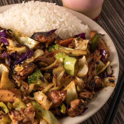 Mixed vegetables stir-fried with chicken and side of rice.
