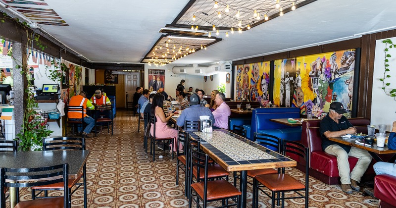 Cozy and spacious interior of Mexican restaurant, dining area with guests enjoying their food