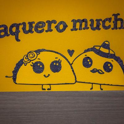 Yellow wall with cute taco characters with faces and 'Taquero Mucho' above them.