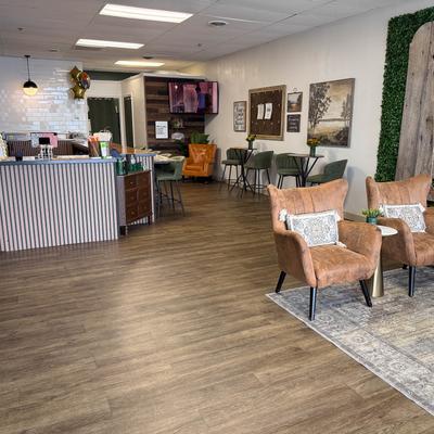 Interior with two large brown armchairs, smaller green chairs and bar counter.