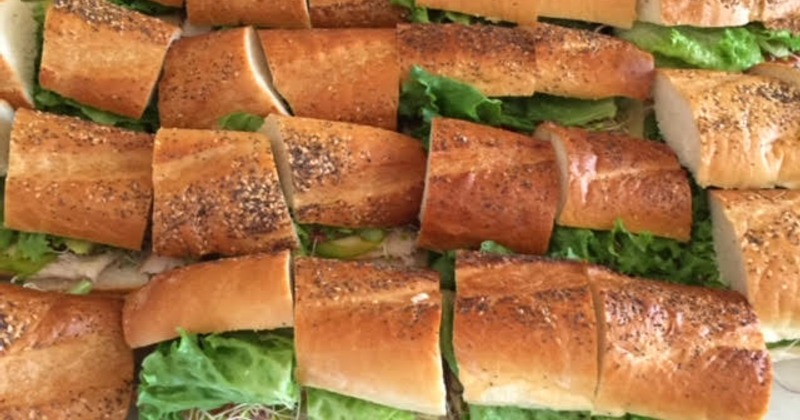 Multiple sub sandwiches with lettuce arranged on a tray