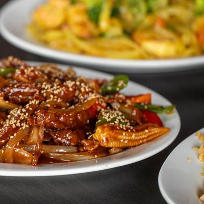 Sesame Chicken, sauteed with pea pods, peppers, onions, baby corn, and carrots.