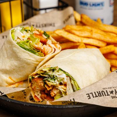 Chicken Caesar Wrap served with fries on the side.