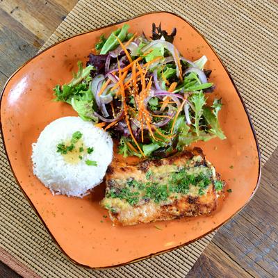 A grilled fish, rice, and salad on an orange plate.