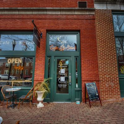 Exterior with red brick facade and a green door and window frames.