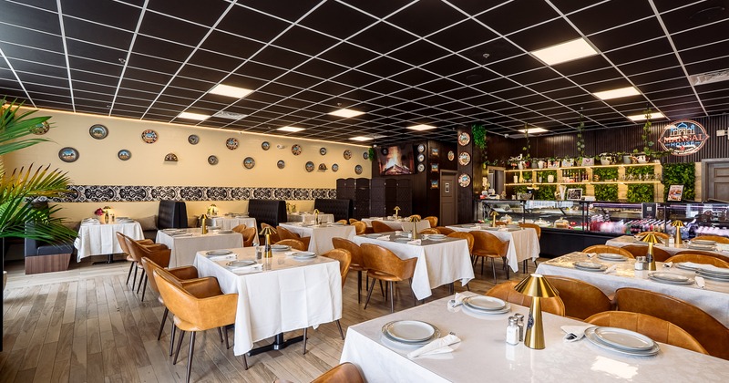 Modern and spacious interior dining area with set dining tables and brown leather chairs