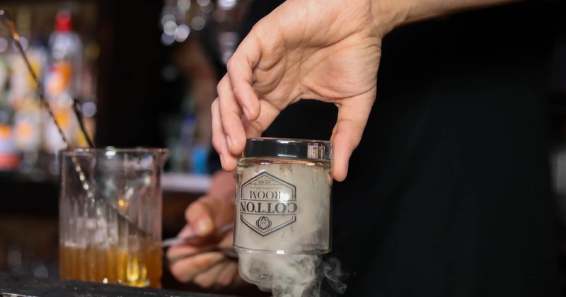Bartender smoking an upturned glass for Old Fashioned cocktail