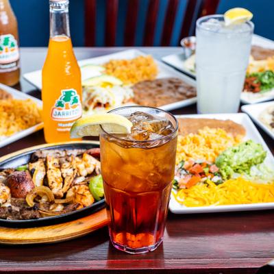 Several iced drinks served on the table alongside bottles of soda and various dishes.