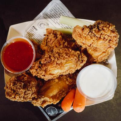 Breaded chicken wings with carrots, celery sticks, and dipping sauces.