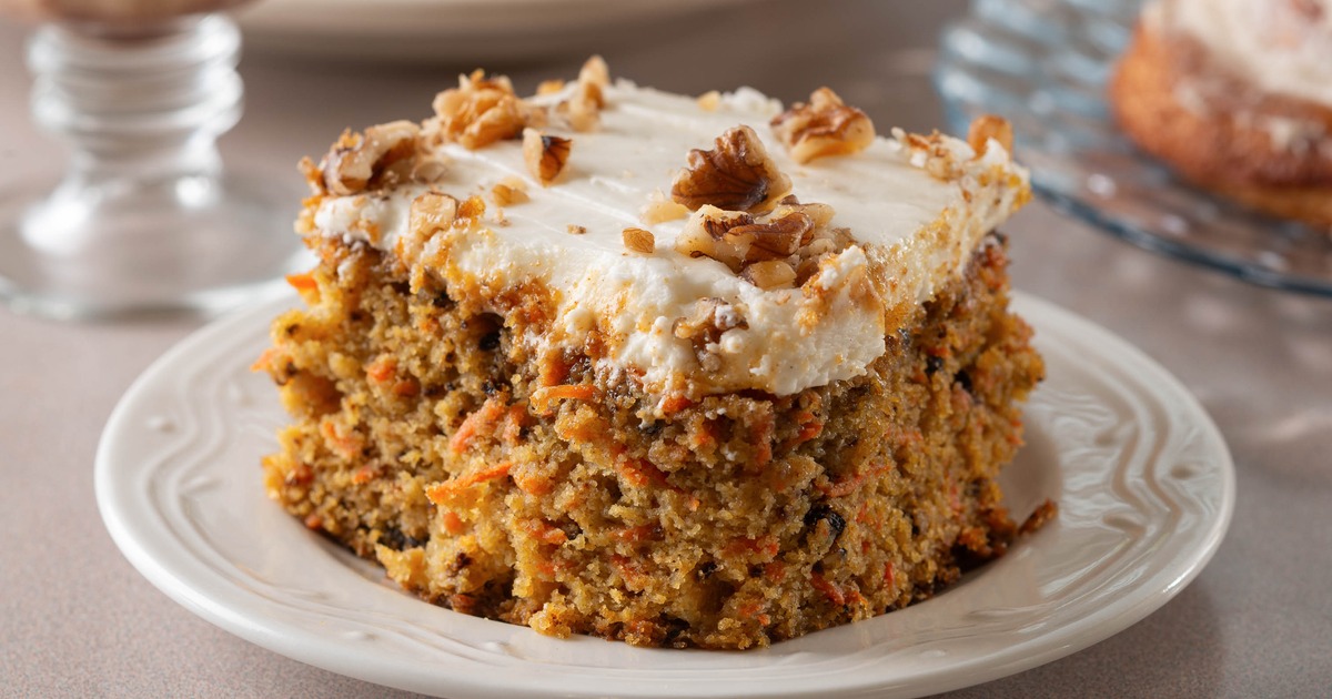 Carrot cake slice topped with frosting and walnuts