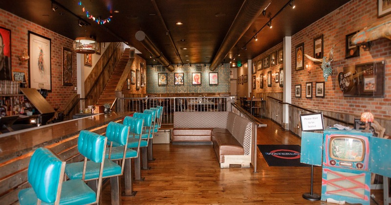 Interior, counter, tables, upholstered seats, decorations, lighting, bare-brick walls