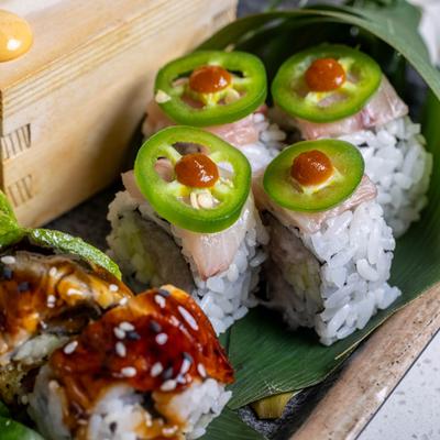 Amazing Yellowtail Roll served on a platter alongside other sushi rolls.