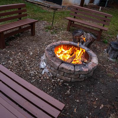 The fire pit outside and benches around it.