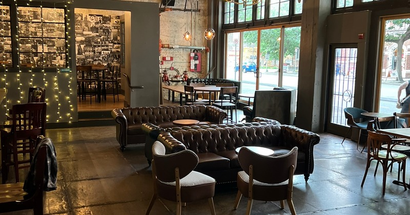 Cozy, industrial-style lounge seating area with leather sofas arranged around low tables
