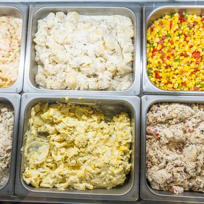 Various salads in metal trays.