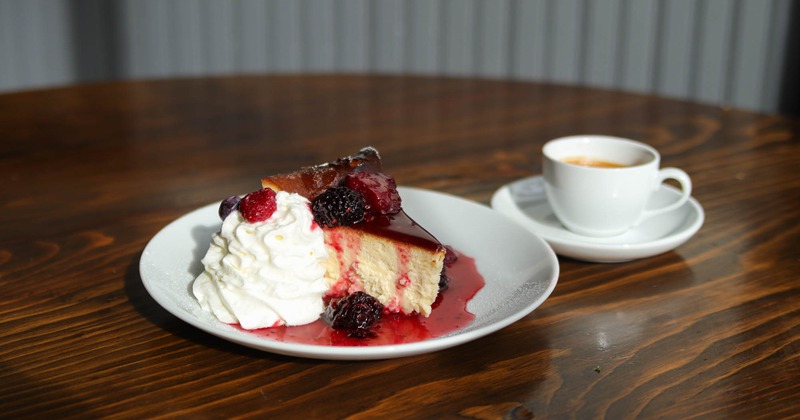 Cheesecake with berries and cream, and a cup of cappuccino