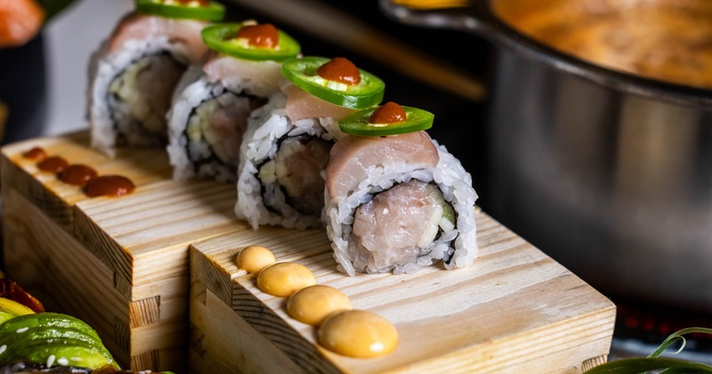 Amazing Yellowtail Roll garnished with jalapeno slices and dots of hot sauce