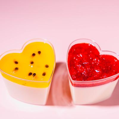 Two heart-shaped desserts, one with passion fruit and one with strawberry.