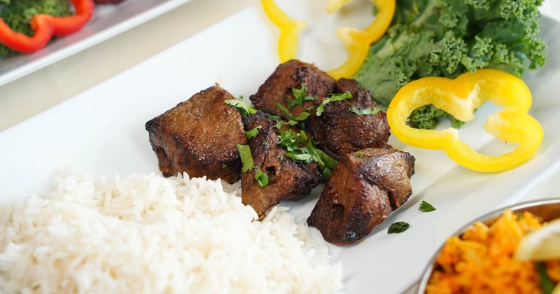 Beef kebab with a side of rice and kale salad, close-up