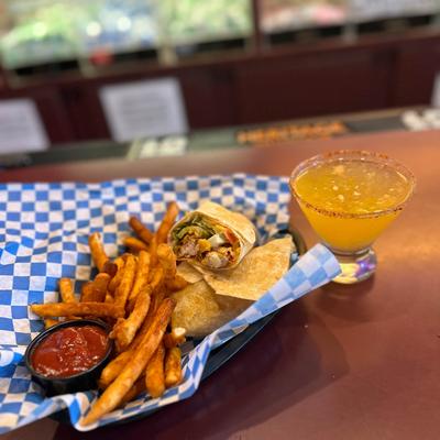 A chicken wrap with fries and a cocktail.