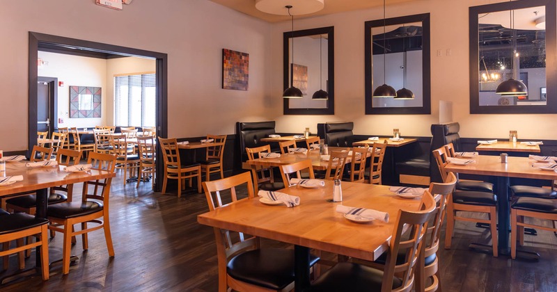 Interior, wide view of dining area, tables ready for guests