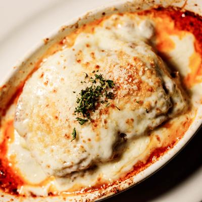 Beef Lasagne topped with melted cheese and herbs, close-up.