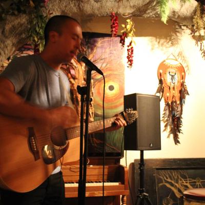 A person singing and playing the acoustic guitar.